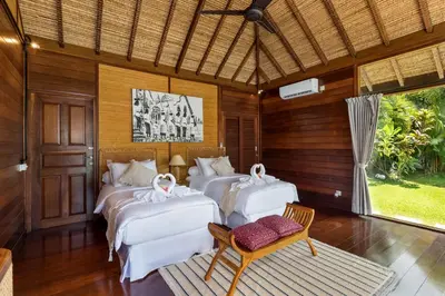 three beds in a room with wooden walls at Palm Merah Villa in Umalas