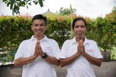 two men in white shirts are folding their hands at Palm Merah Villa in Umalas