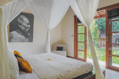 a bedroom with a bed with a large window at Villa Charlie Seminyak in Badung