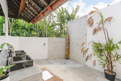 a patio with a sink and a wall with plants at Villa Charlie Seminyak in Badung