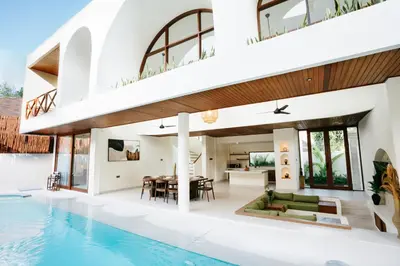 an open living room and dining area of a house with a swimming pool at Luxury Villa Noah in Kuta