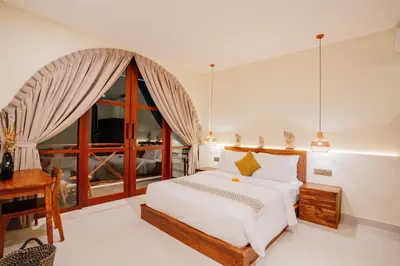 a bedroom with a bed and a desk and a window at Luxury Villa Noah in Kuta