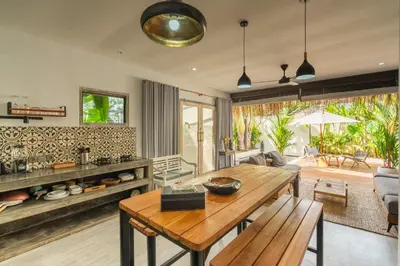 a kitchen and living room with a wooden table at Lovely 1 BR villa walking distance to the beach in Seminyak