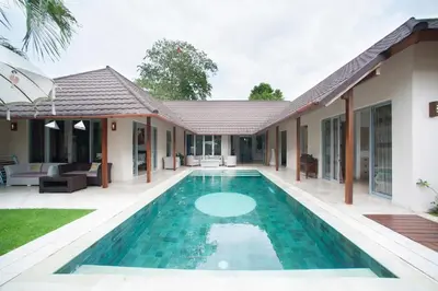a villa with a swimming pool in front of a house at J & J villa Seminyak in Seminyak
