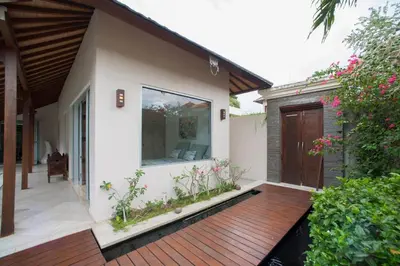 a wooden deck in front of a house at J & J villa Seminyak in Seminyak