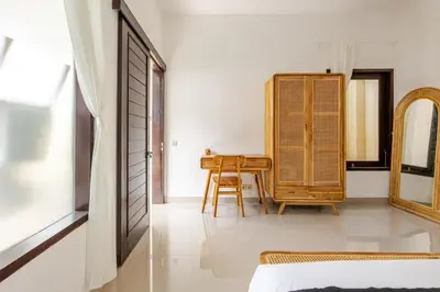a room with a table and a chair and a mirror at Gemstones Villa in Seminyak