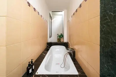 a bathroom with a bath tub and a sink at Gemstones Villa in Seminyak