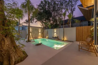 a swimming pool in a backyard with a tree at Vaya - Luxe & Stylish 3BR Villa Just Steps from the Beach in Seminyak