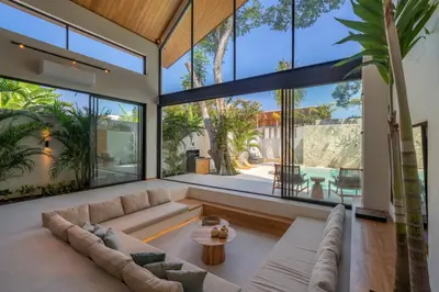 a living room with a couch and large windows at Vaya - Luxe & Stylish 3BR Villa Just Steps from the Beach in Seminyak