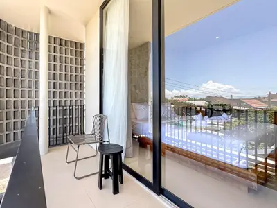 a room with a balcony with a table and a chair at Saint Cloud Villa Umalas in Canggu