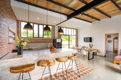an open kitchen with a bar and a living room at Villa Anzo by DreamAwayBali in Seminyak