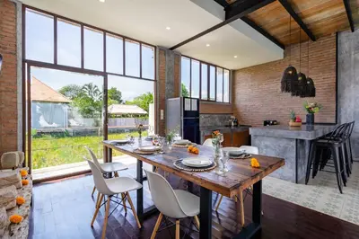 a kitchen and dining room with a wooden table and chairs at Villa Anzo by DreamAwayBali in Seminyak
