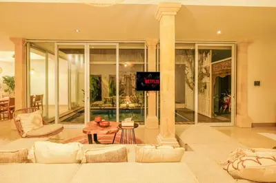 a living room with a couch and a tv at Casa De Beji Seminyak in Seminyak