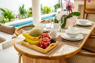 a wooden table with a plate of fruit on it at La Feliz Villa Seminyak in Seminyak