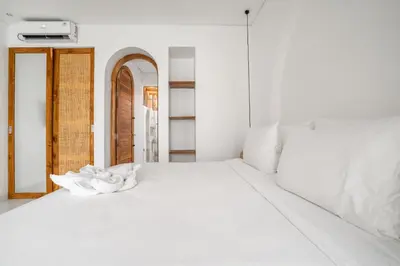 a white bed with a white flower on it at La Feliz Villa Seminyak in Seminyak