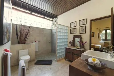 a bathroom with a tub and a toilet and a sink at Villa Eight in Seminyak