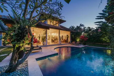 a villa with a swimming pool in front of a house at Villa Eight in Seminyak