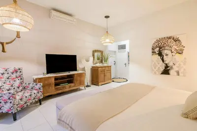a bedroom with a bed and a flat screen tv at Villa Bloom 3 - Coastal Beach Villa 2 brm Sleeps 4 SEMINYAK BEACH in Seminyak