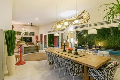 a kitchen and dining room with a wooden table and chairs at Villa Bloom 3 - Coastal Beach Villa 2 brm Sleeps 4 SEMINYAK BEACH in Seminyak