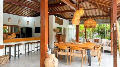 a dining room and kitchen with a wooden table and chairs at Villa Sukacita - Family Friendly 4BR Seminyak Eat Street 900m Walk To Beach in Seminyak