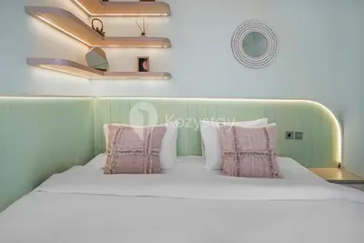 a bedroom with a white bed with pink pillows at Calisee Villa by Kozystay - Denpasar in Seminyak