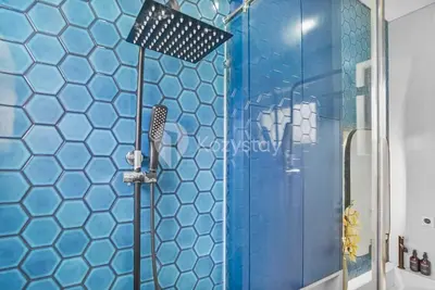 a bathroom with a shower with a blue tiled wall at Calisee Villa by Kozystay - Denpasar in Seminyak