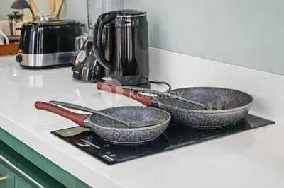 two frying pans sitting on a tray on a kitchen counter at Calisee Villa by Kozystay - Denpasar in Seminyak
