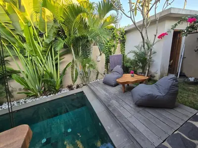 a patio with a table and chairs and a pool at Villa crush of heart with swimming pool in Umalas