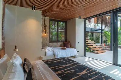 a bedroom with a bed and sliding glass doors at Villa Baratega - Dreamy Urban Tropical 6BR Villa for Large Group in Kerobokan