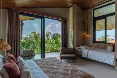 a bedroom with two beds and a large window at Villa Baratega - Dreamy Urban Tropical 6BR Villa for Large Group in Kerobokan