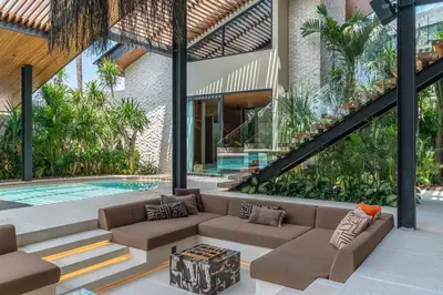 a living room with a couch and a swimming pool at Villa Baratega - Dreamy Urban Tropical 6BR Villa for Large Group in Kerobokan
