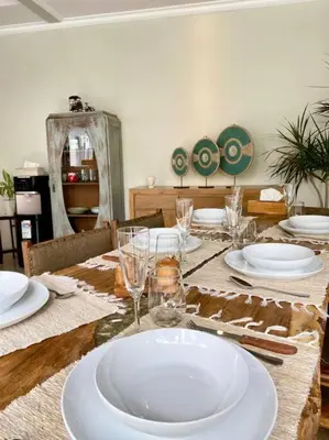 a dining room table with plates and glasses on it at Tranquil Family Villa Retreat in Umalas in Kerobokan