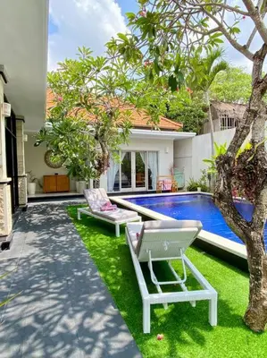a yard with two chairs and a swimming pool at Tranquil Family Villa Retreat in Umalas in Kerobokan