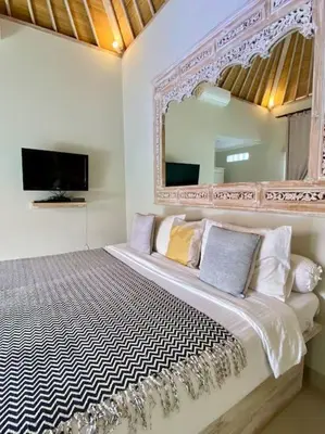 a bedroom with a large bed with a mirror at Tranquil Family Villa Retreat in Umalas in Kerobokan