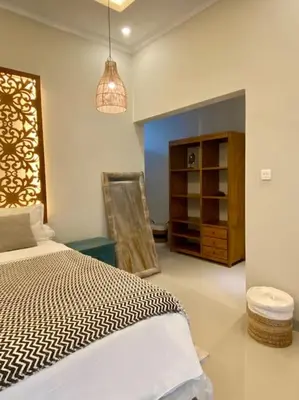 a bedroom with a bed and a cabinet in it at Tranquil Family Villa Retreat in Umalas in Kerobokan