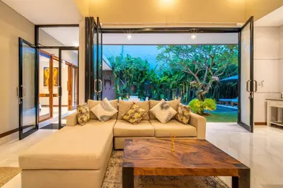 a living room with a couch and a large window at Cozy villa in Umalas in Kerobokan