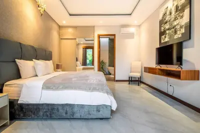 a bedroom with a large bed and a flat screen tv at Cozy villa in Umalas in Kerobokan