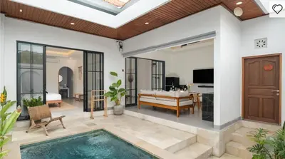 a villa with a swimming pool and a living room at Private Pool Seminyak Central 2BR Villa in Seminyak
