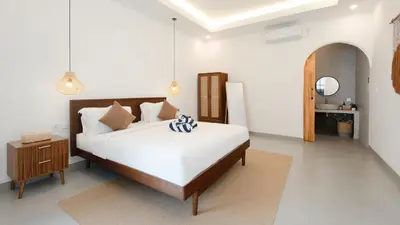a bedroom with a large white bed and a table at Private Pool Seminyak Central 2BR Villa in Seminyak
