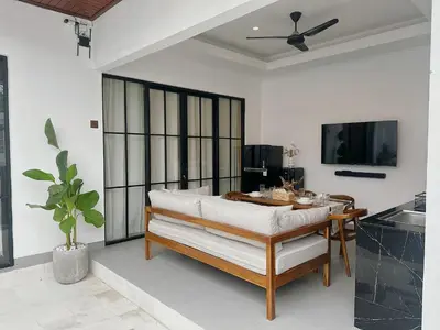 a dining room with a table and a ceiling fan at Private Pool Seminyak Central 2BR Villa in Seminyak