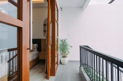 a hallway of a house with a staircase and a plant at The Lavana Sahadewa Villa Kuta Sunset in Legian