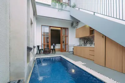 a house with a swimming pool in the middle of a building at The Lavana Sahadewa Villa Kuta Sunset in Legian