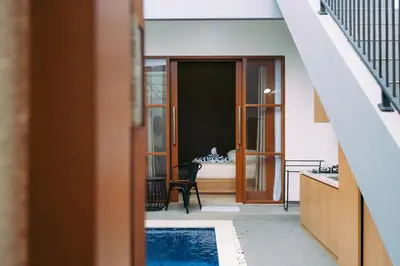 a house with a swimming pool and a bedroom at The Lavana Sahadewa Villa Kuta Sunset in Legian