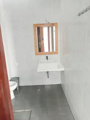 a white bathroom with a sink and a toilet at Double D Guesthouse and Villa in Kerobokan