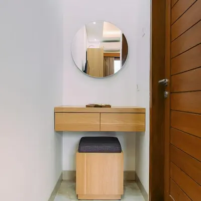 a bathroom with a vanity with a mirror and a stool at The Lavana Nakula Villa Kuta Sunset in Kuta