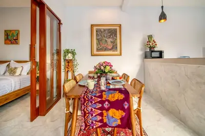 a dining room with a table and chairs and a bed at Arts Tamansari Villa Two-Bedroom Private Pool Kuta in Kerobokan