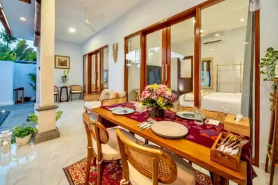 a dining room with a wooden table and chairs at Arts Tamansari Villa Two-Bedroom Private Pool Kuta in Kerobokan