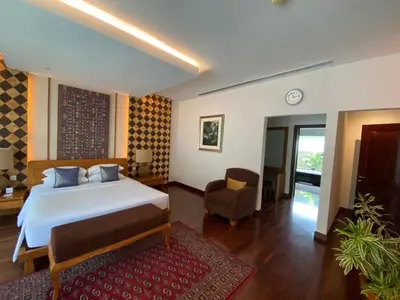 a bedroom with a bed and a chair in it at Bintang Bali Villa in Kuta