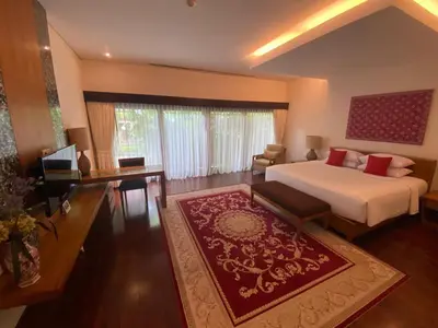 a bedroom with a bed and a living room at Bintang Bali Villa in Kuta