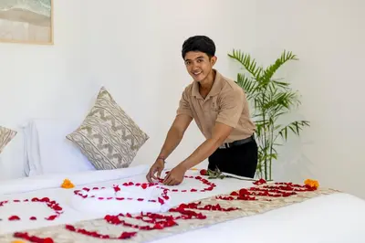 a man cutting a cake on a bed at Villa Lilja in Seminyak